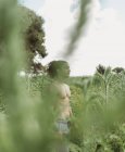 Homme barbu sportif méditant sur une prairie idyllique tranquille contre le ciel bleu — Photo de stock