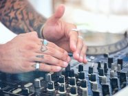 Anonymous DJ tuning music during party — Stock Photo