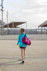 Visão traseira do Sportswoman segurando saco enquanto se afasta — Fotografia de Stock