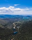 Aerial view of beautiful landscape, blue cloudy sky and lakes surrounded by forests and mountains — Stock Photo