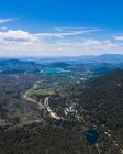 Aerial view of beautiful landscape, blue cloudy sky and lakes surrounded by forests and mountains — Stock Photo