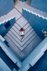 Top view of Beautiful woman sitting on blue staircase of blue building and using computer — Stock Photo