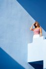 Woman standing on top of blue building with closed eyes — Stock Photo