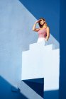 Frau steht auf blauem Gebäude und schaut weg — Stockfoto