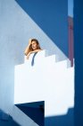 Mulher de pé no topo do edifício azul e olhando para a câmera — Fotografia de Stock
