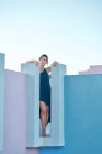 Женщина стоит на вершине синего здания и смотрит в сторону — стоковое фото
