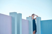 Donna in piedi sulla cima di un edificio blu e guardando la fotocamera — Foto stock