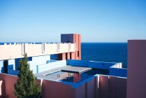 Incredibile piscina con acqua dolce che riflette il cielo sul tetto di interessante edificio a forma di giornata di sole luminoso — Foto stock