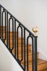 Цельная деревянная лестница с черными перилами в доме с легким интерьером — стоковое фото