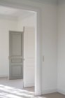 Porta aperta a battente bicolore con maniglia moderna in bianco interno minimalista — Foto stock