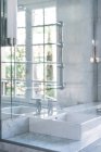 Квадратний білий умивальник і сталевий кран у шикарній ванній в денне світло — стокове фото