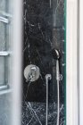 Torneira de chuveiro brilhante cromado e suporte em cabine de mármore em casa de luxo — Fotografia de Stock