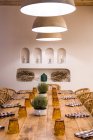 Paralumi classici con luce calda appesi sopra il tavolo in legno impostato nella sala luce — Foto stock