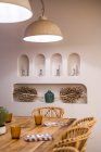 Класичні абажури з теплим світлом, що звисає над встановленим дерев'яним столом у світлій залі — стокове фото