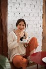 Мирная женщина пьет кофе, отдыхая дома — стоковое фото