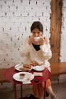 Mulher pacífica bebendo café enquanto descansa em casa — Fotografia de Stock