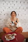 Мирная женщина пьет кофе, отдыхая дома — стоковое фото