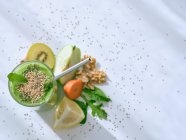 Set de ingredientes para batido saludable y vaso con bebida verde - foto de stock