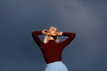 Schöne Blondine posiert gegen den Himmel — Stockfoto