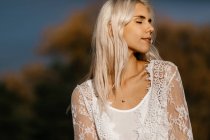 Beautiful blonde woman gazing at autumn countryside — Stock Photo