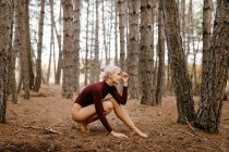 Schöne moderne Frau, die barfuß im immergrünen Wald ruht — Stockfoto