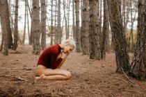 Красива сучасна жінка відпочиває босоніж у вічнозеленому лісі — стокове фото