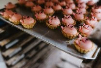 Металевий піднос зі смачною свинячою випічкою, розміщеною на стійці у професійній пекарні — стокове фото