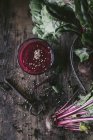 Glas köstlicher Rote-Bete-Smoothie mit Sesam auf Holztisch mit rohem Gemüse und Vintage-Schlüssel — Stockfoto