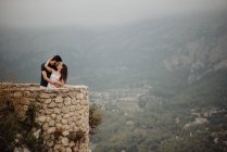 Романтична пара цілується, насолоджуючись видом на сільську місцевість на гірській оглядовій палубі — стокове фото