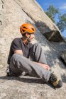 Скельний альпініст одягає взуття для скелелазіння, щоб почати сходження — стокове фото