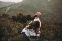 Un couple affectueux s'amuse dans une vallée vallonnée — Photo de stock