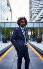 Serious african american entrepreneur in formal clothing and with curly hair looking at camera — Stock Photo