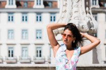 Entspannte schöne Frau im trendigen Outfit sitzt auf Steintreppe auf malerischer Straße — Stockfoto