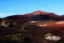Picturesque view of volcanic terrain with solidified lava in wild area on island of Lanzarote Spain — Stock Photo