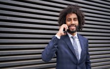 Afrikanisch-amerikanischer Mann telefoniert in der Nähe einer Mauer — Stockfoto
