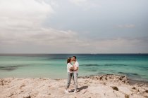 Loving couple embracing on coastline — Stock Photo