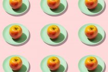 Frischer Apfel im Teller auf rosa Hintergrund. Lebendiges buntes Muster — Stockfoto
