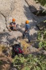 Скельний альпініст одягає взуття для скелелазіння, щоб почати сходження — стокове фото