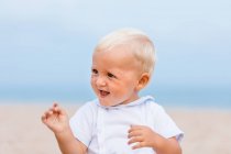 Retrato de um bebê loiro sorrindo na praia — Fotografia de Stock