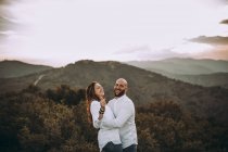 Una pareja afligida que se divierte en un valle montañoso - foto de stock