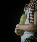 Vista laterale della donna con bottiglia di sciroppo di fiori di sambuco — Foto stock