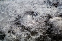 Танення льоду та снігу на кам'янистій поверхні з галькою під час денного світла — стокове фото