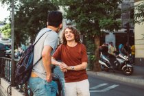 Spensierato interessati uomini multietnici in abiti casual parlando mentre in piedi strada della città — Foto stock