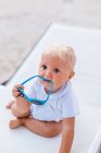 Portrait of a blonde baby playing with sunglasses — Stock Photo