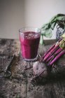 Ripe organic delicious beetroot on wooden table with glass of fresh smoothie and vintage key — Stock Photo
