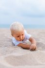 Vista frontal de un bebé rubio en la playa - foto de stock