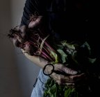 Unrecognizable woman holding bunch of beetroots and vintage key in hand — Stock Photo