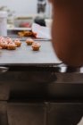 Маленькие десерты со свиными ушами и мордой помещены на металлический поднос в пекарне — стоковое фото