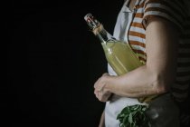 Vue latérale de la femme avec bouteille de boisson de sureau — Photo de stock