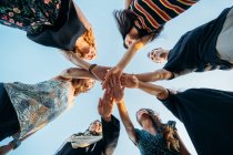 A group of friends joining hands making a promise on the beach — Stock Photo